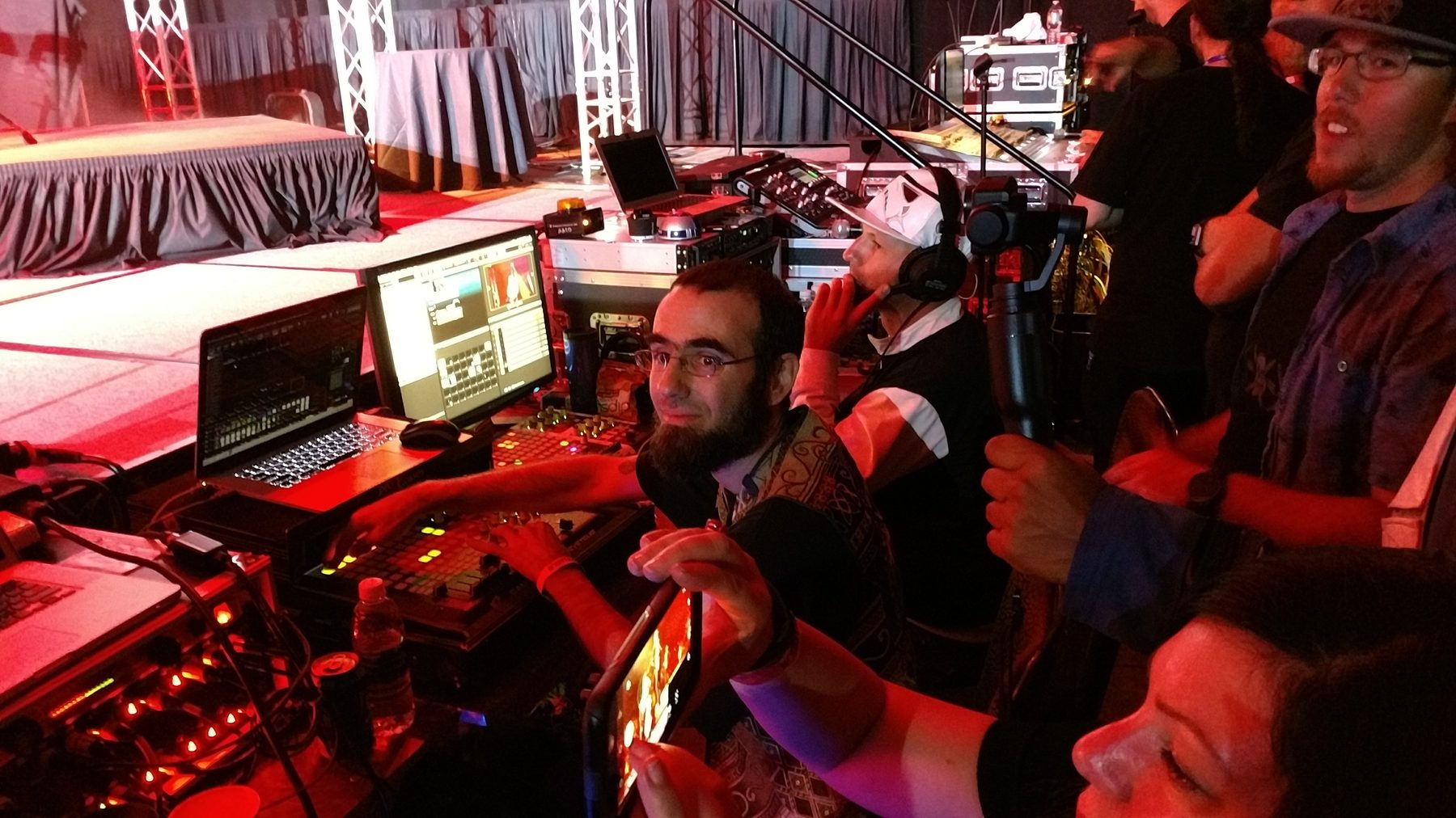 Front of house position with video monitors and operators working under red stage light